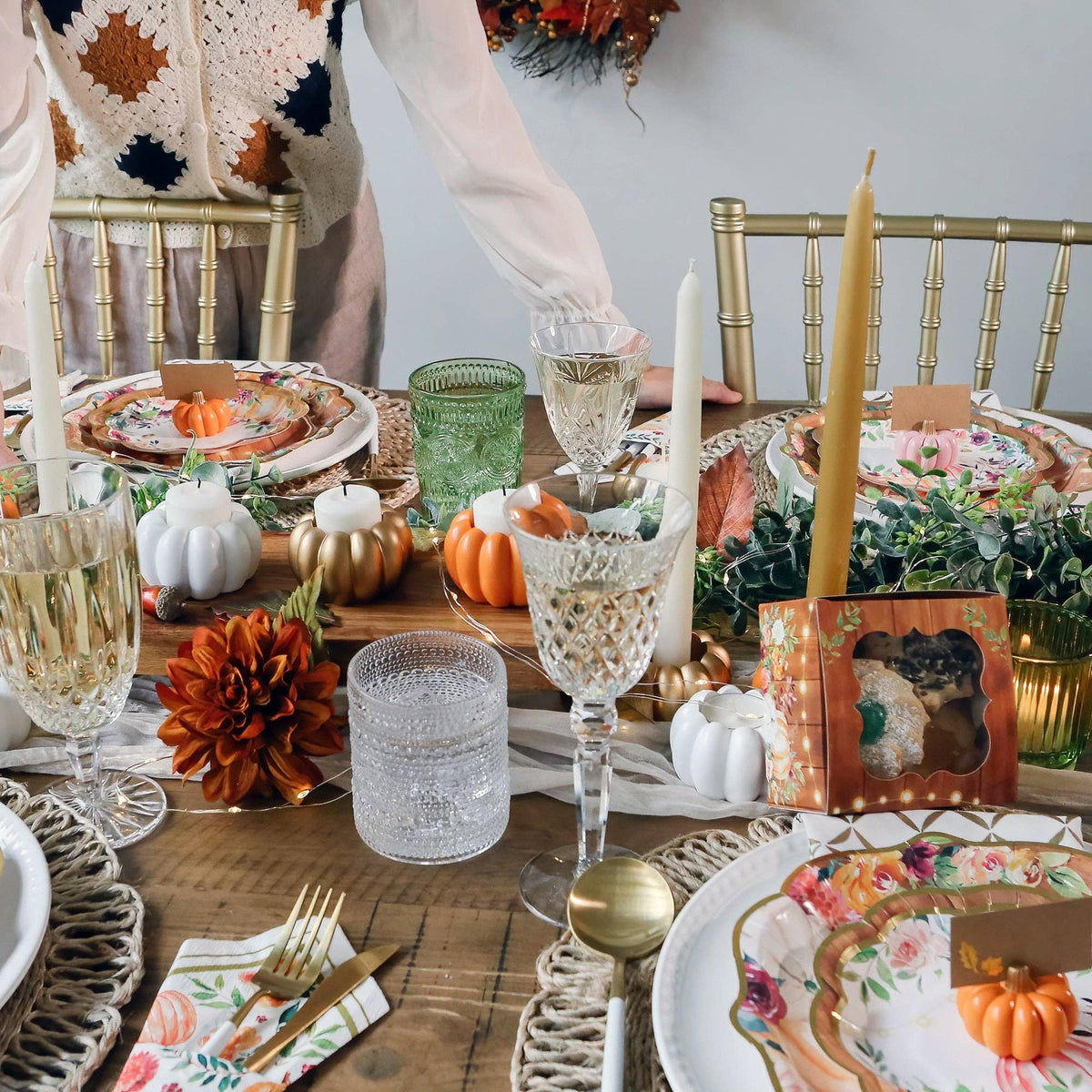 Mellow Monkey orange pumpkin place card holders arranged on a festive Thanksgiving dinner table with gold accents