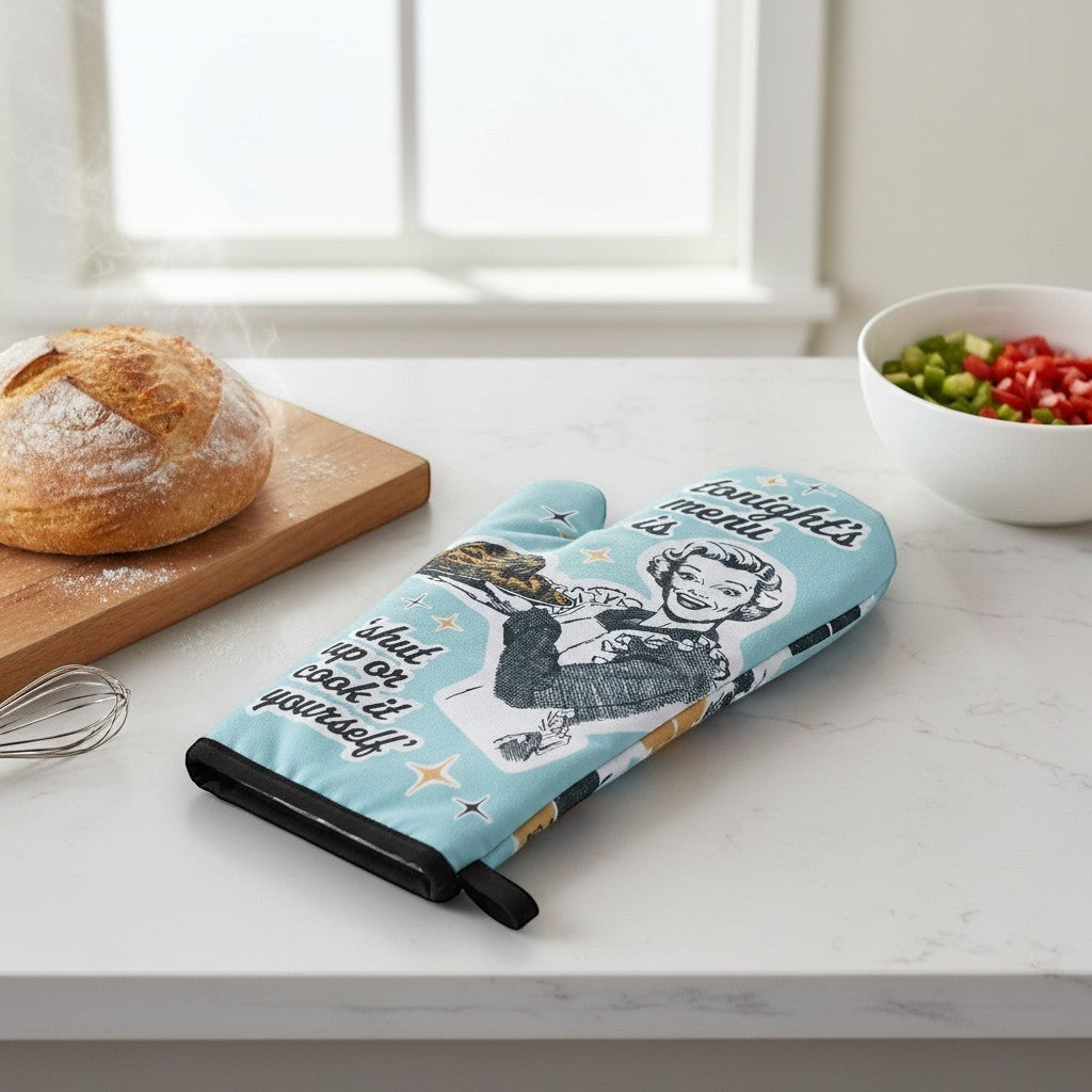 Mellow Monkey light blue oven mitt with retro illustration of a woman serving food and text 'tonight's menu is shut up or cook it yourself'