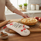 Mellow Monkey cream oven mitt with red cherries and "I bake because therapy is expensive" text. Heat resistant.