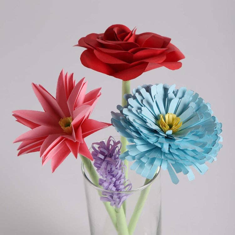 Mellow Monkey paper flower craft kit featuring a red rose, pink lily, blue carnation, and purple lavender in a vase.