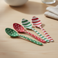 Mellow Monkey stainless steel spoons featuring festive red, green, and white polka dot and striped patterns.