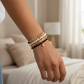Mellow Monkey bracelet stack featuring freshwater pearls, black crystals, gold chain, and a gold star charm on a wrist