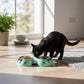 Mellow Monkey Peeking Kitty Double Pet Bowl in mint green with cat face design, holding kibble and water.