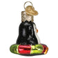 Mellow Monkey Mini Penguin Old World Christmas blown glass ornament, black and white with orange beak, on a red and green float.