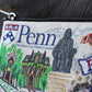 Mellow Monkey University of Pennsylvania woven zip pouch with iconic campus buildings and mascot. Features metallic thread and collegiate lining.