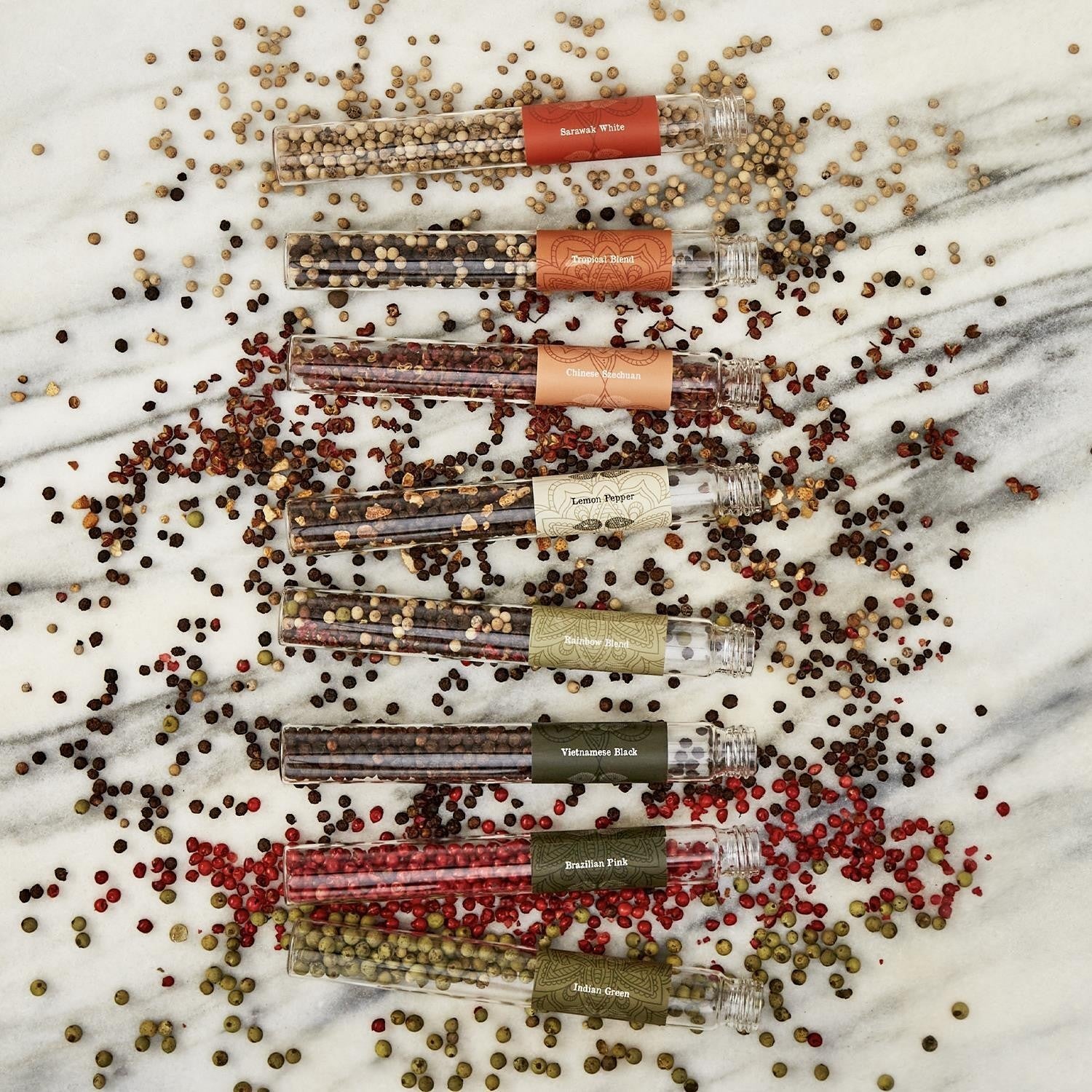 Mellow Monkey The Pepper Trade 8-tube gourmet peppercorn gift set with Sarawak White, Tropical Blend, Chinese Szechuan, Lemon Pepper, Rainbow Blend, Vietnamese Black, Brazilian Pink, and Indian Green.