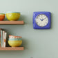 Mellow Monkey periwinkle retro square wall clock with white face and blue hands, 9.25-in