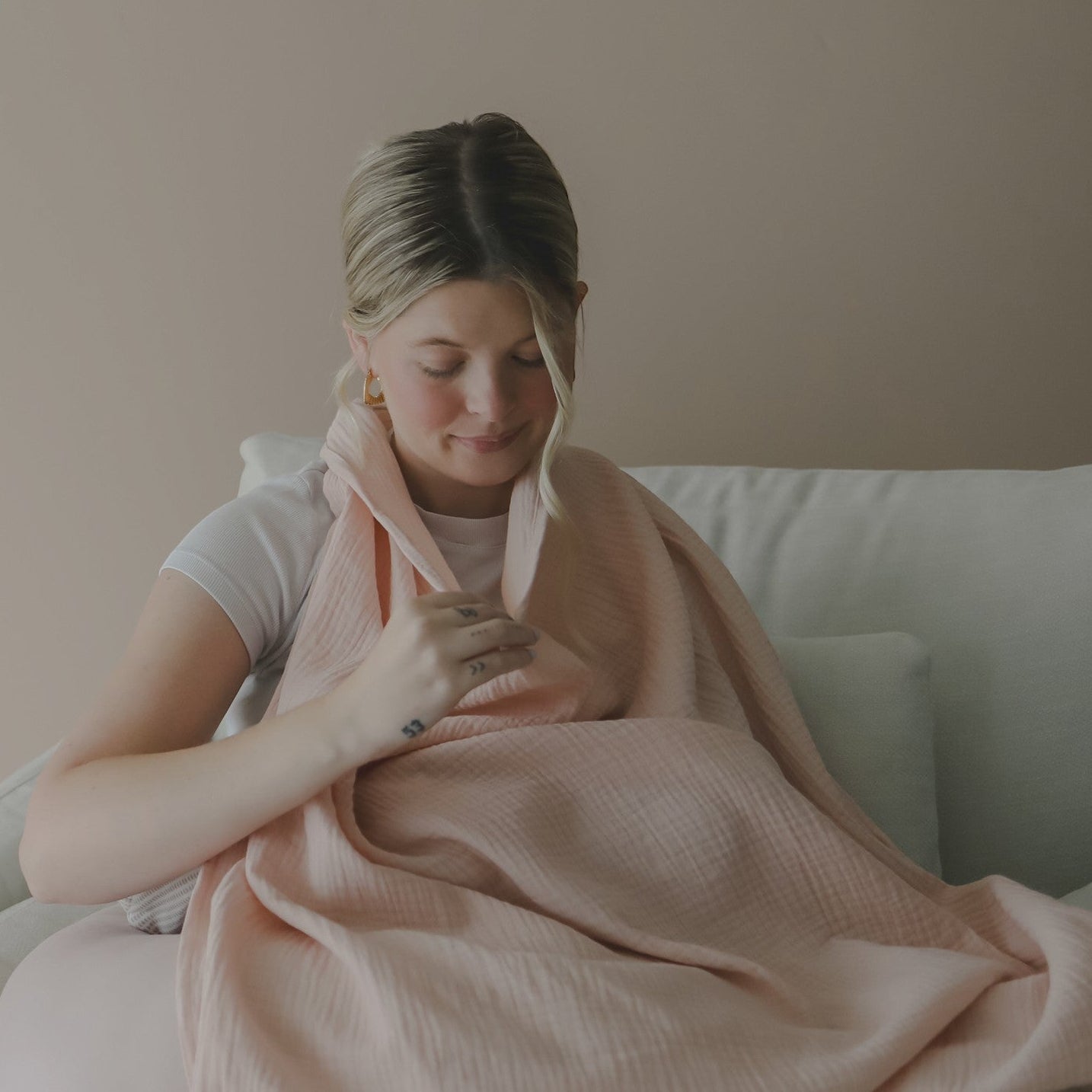 Mellow Monkey Petal nursing cover in soft pink organic cotton muslin with a built-in silicone teether for mothers.