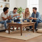 Mellow Monkey Phase 10 card game being played by four friends laughing and sitting on a sofa in a bright living room