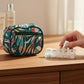 Mellow Monkey zippered pill & vitamin case in a teal "Meadow" print with coral, pink, and blue abstract floral design. Features a front zip pocket.
