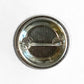 Back view of a 1.25-inch Mellow Monkey pin-back button featuring a tin-coated steel shell and a secure metal pin clasp.