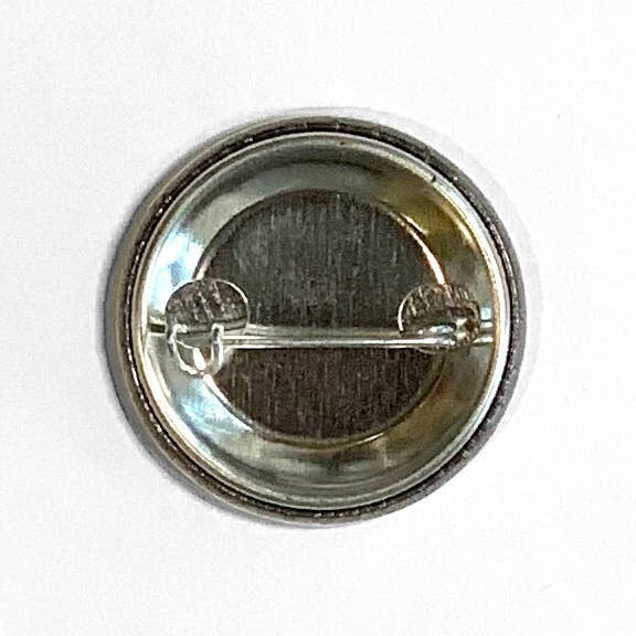 Mellow Monkey 1.25 inch round pin-back button showing the metal backer and clasp mechanism