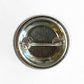 Back view of a 1.25 inch Mellow Monkey pin-back button showing the metal shell and clasped pin mechanism.