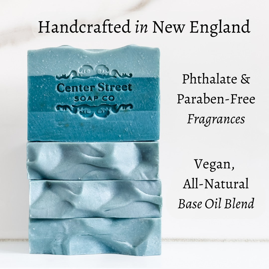 Mellow Monkey handcrafted blue exfoliating pine soap bars stacked with natural textures and embossed branding.