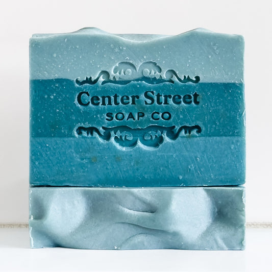 Mellow Monkey Pine Grit exfoliating handmade bar soap in blue with embossed Center Street Soap Co logo