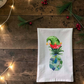 Mellow Monkey flour sack towel featuring a festive sea glass pineapple wearing a green and red elf hat
