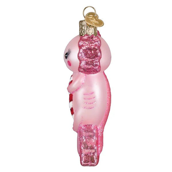 Mellow Monkey pink glass axolotl ornament holding a red and white candy cane, with glitter accents.