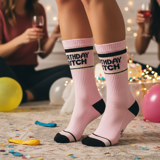 Mellow Monkey pink mid-calf gym crew socks with Birthday Bitch text, worn at a birthday party celebration.