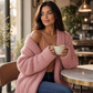 Mellow Monkey pink chunky knit cardigan with thick front placket worn by a woman holding a coffee in a cafe