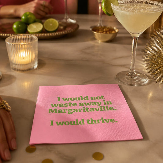 Mellow Monkey pink cocktail napkin with green text reading I would not waste away in Margaritaville. I would thrive.