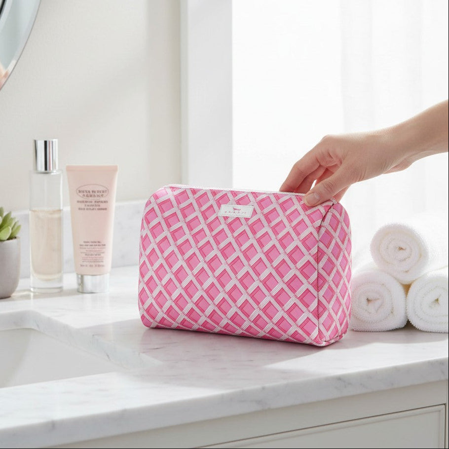 Mellow Monkey Garden Gate toiletry bag in pink and white diamond pattern on a marble bathroom counter
