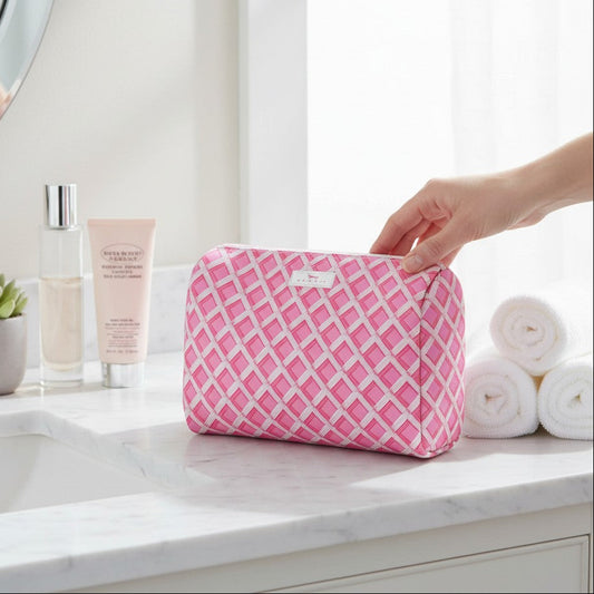 Mellow Monkey Garden Gate toiletry bag in pink and white diamond pattern on a marble bathroom counter