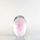 Mellow Monkey pink glass jellyfish paperweight with delicate tentacles encased in a clear oval dome.