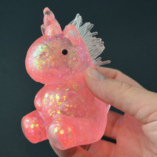 Mellow Monkey pink glittery unicorn squishy toy held in a hand for stress relief and sensory play.