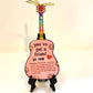 Mellow Monkey pink guitar ornament featuring You've Got A Friend in Me text, rainbow neck, and gold ribbon display.