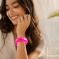 Mellow Monkey FEELZiES Jelly Donut Squishy wearable sensory fidget bracelet in bright pink on a woman's wrist