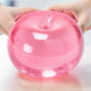 Mellow Monkey Pink Lemonade SlowFlow squishy apple fidget toy being held by two hands on a desk