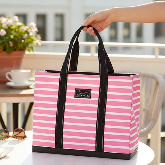 Mellow Monkey Original Deano large tote bag in pink and white stripes with black handles on a patio table