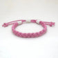 Mellow Monkey pink woven cotton nautical anklet with adjustable sliding knot closure on a white background.
