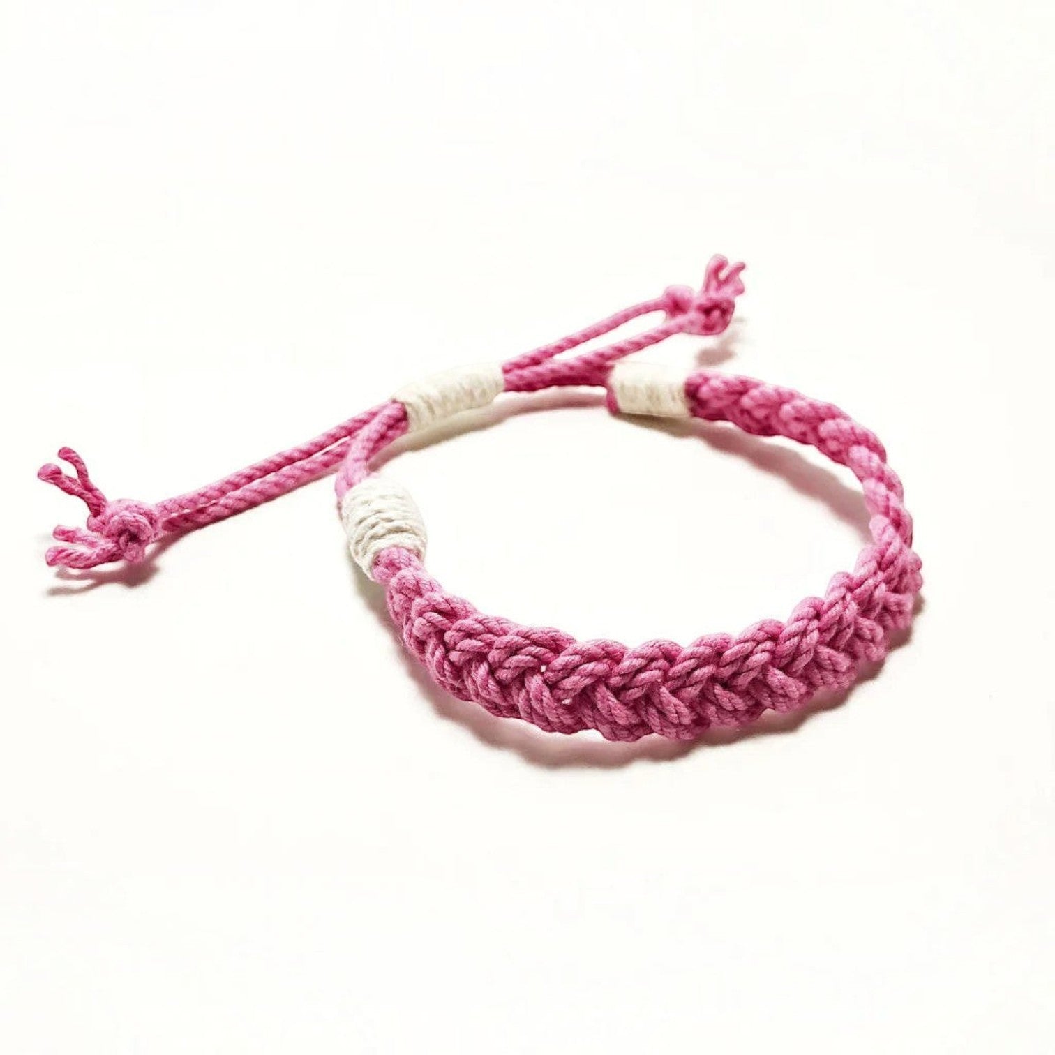 Mellow Monkey pink woven cotton nautical bracelet with adjustable sliding knot closure on a white background