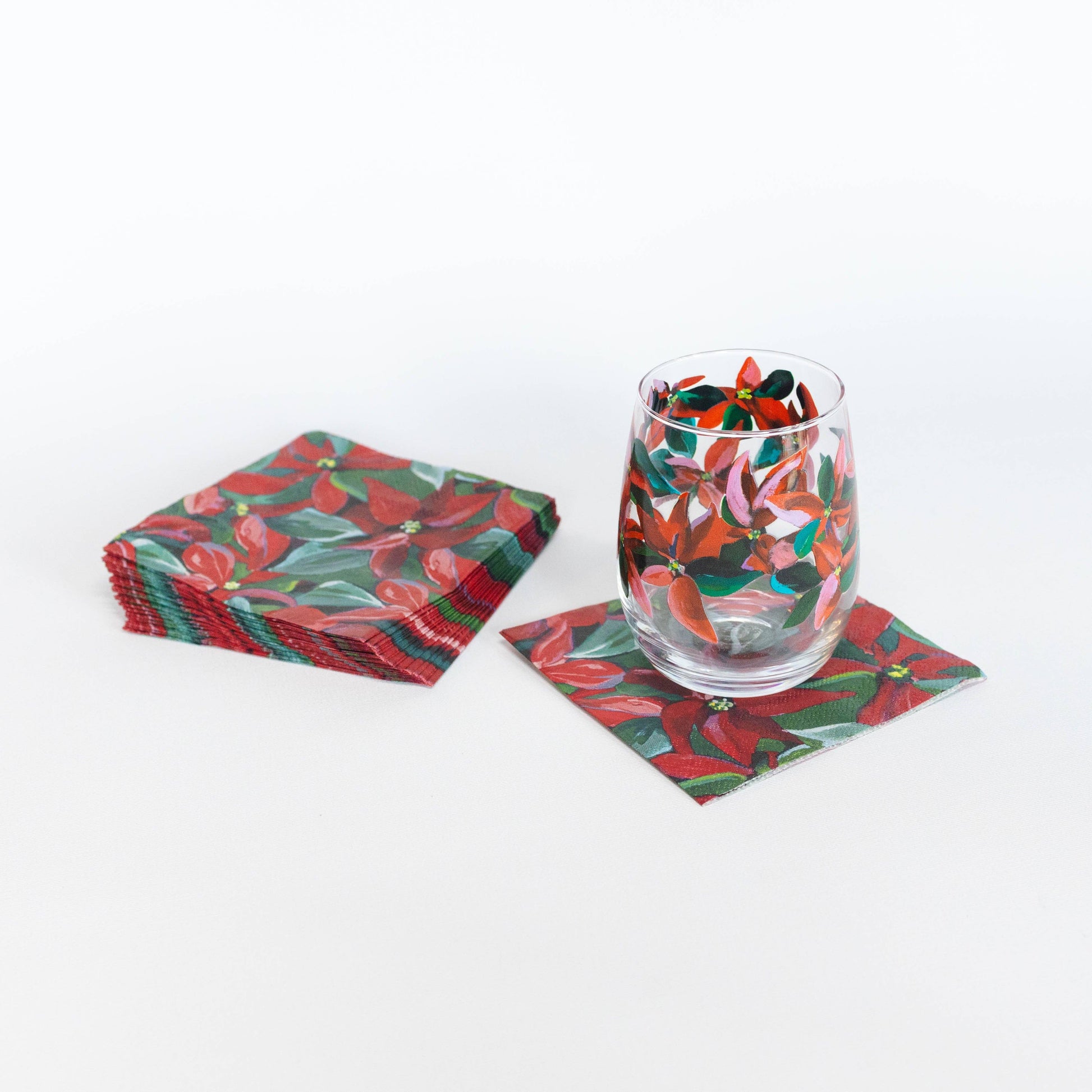 Mellow Monkey cocktail napkins featuring Kim Hovell poinsettia artwork with a matching painted glass on white