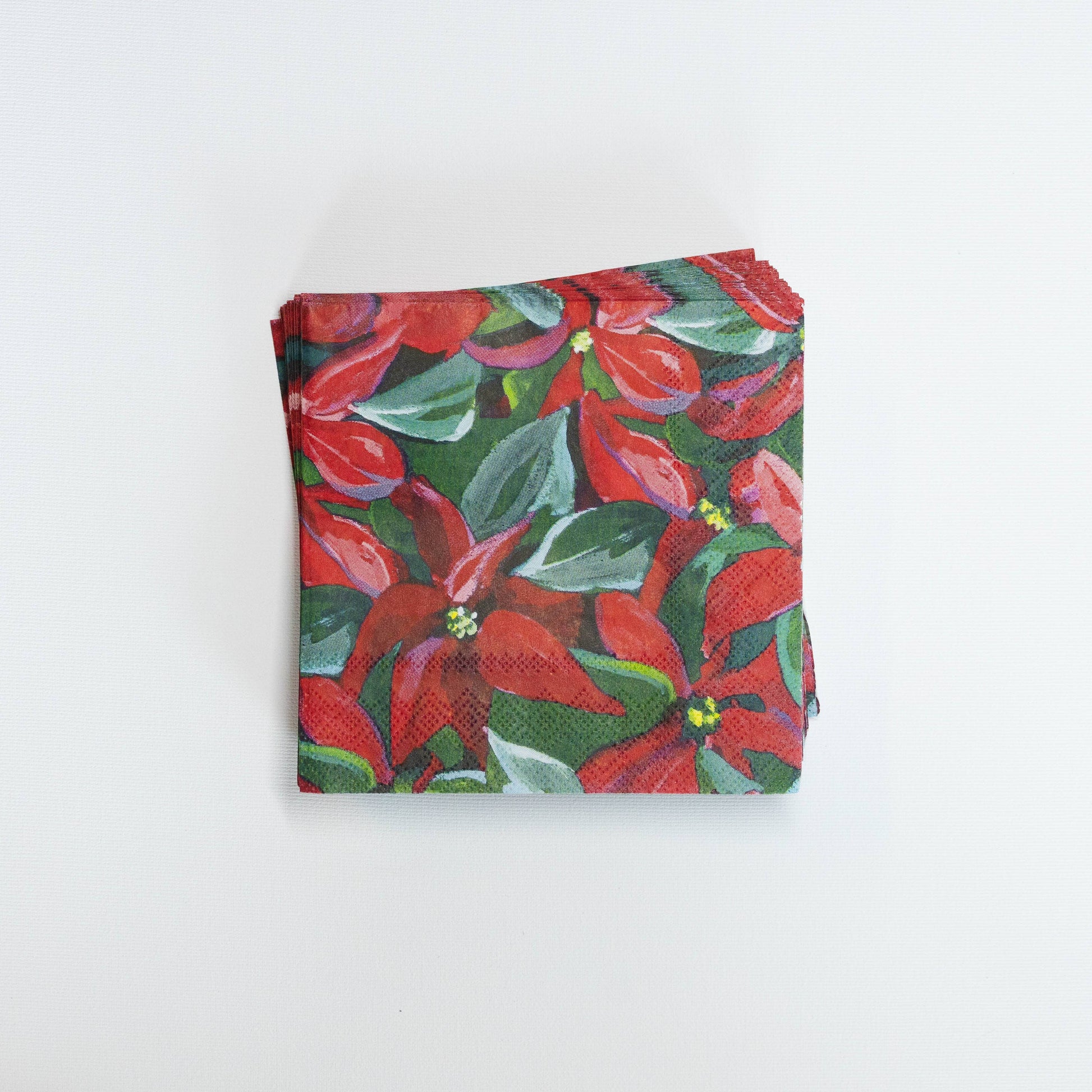 Mellow Monkey cocktail napkins featuring Kim Hovell poinsettia floral artwork in red and green for holiday parties.