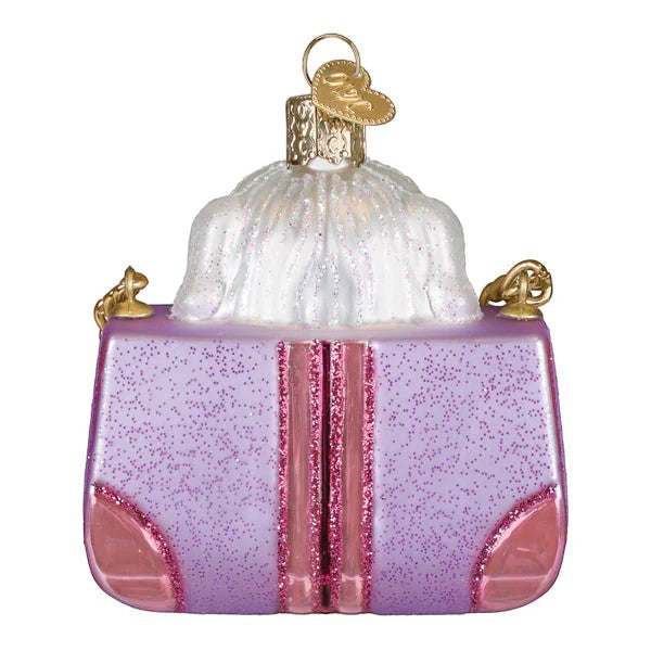 Mellow Monkey Posh Pup In Purse blown glass holiday ornament, 3.25-in. Features a lavender glitter purse with pink accents and a white fluffy dog peeking out.