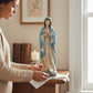 Mellow Monkey resin Praying Mary statue in blue and cream robes, displayed on a wooden table with a lit candle.