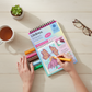 Mellow Monkey Pretty Petals MINI FlowArt dot-by-letter kit with markers and hands coloring a floral design on a desk.