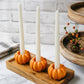 Mellow Monkey set of 3 orange resin pumpkin candle holders on a wooden tray with white taper candles