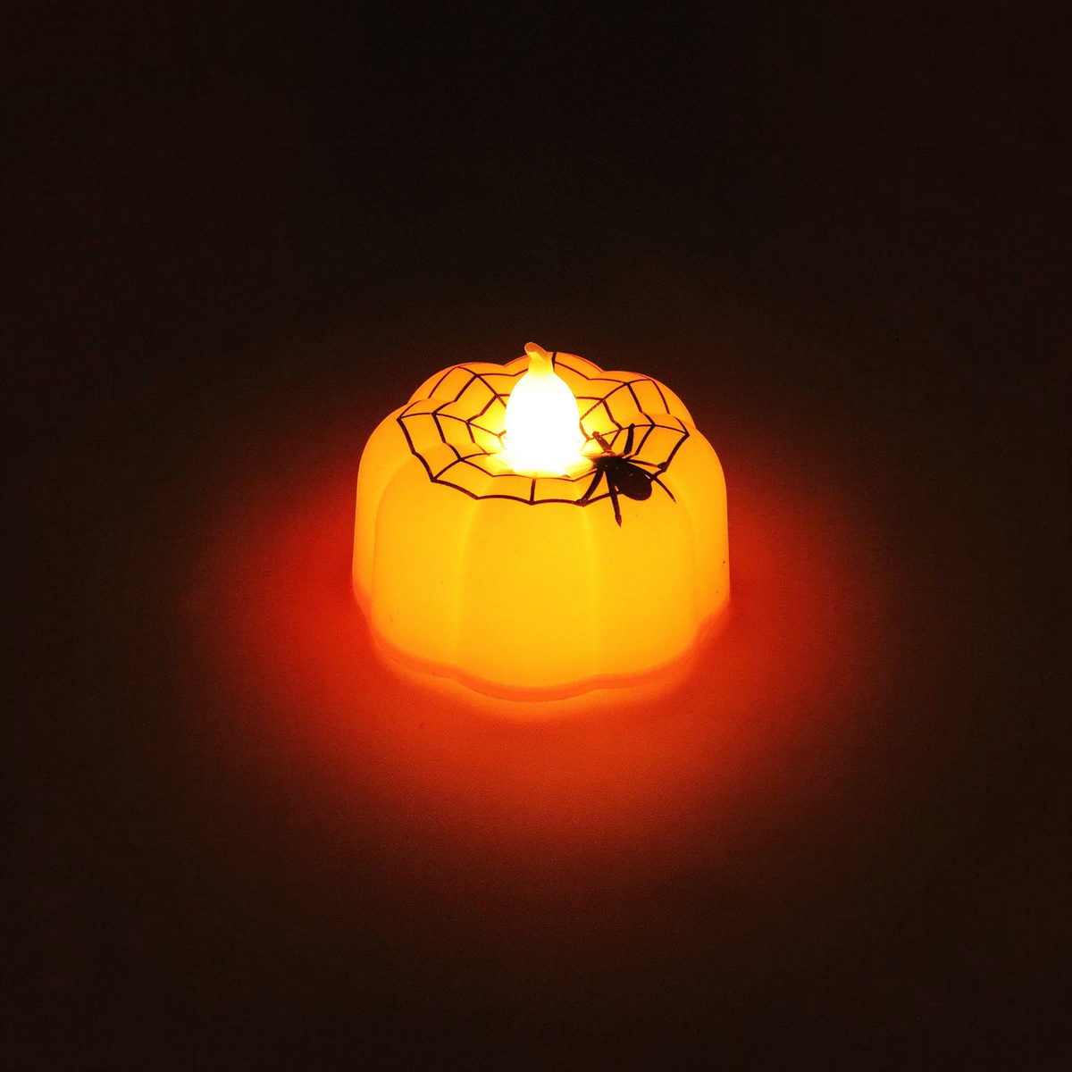 Mellow Monkey mini orange LED pumpkin tealight candle with a black spider and web design for Halloween decor