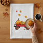 Mellow Monkey white cotton flour sack towel featuring a red Radio Flyer wagon filled with pumpkins and autumn leaves.