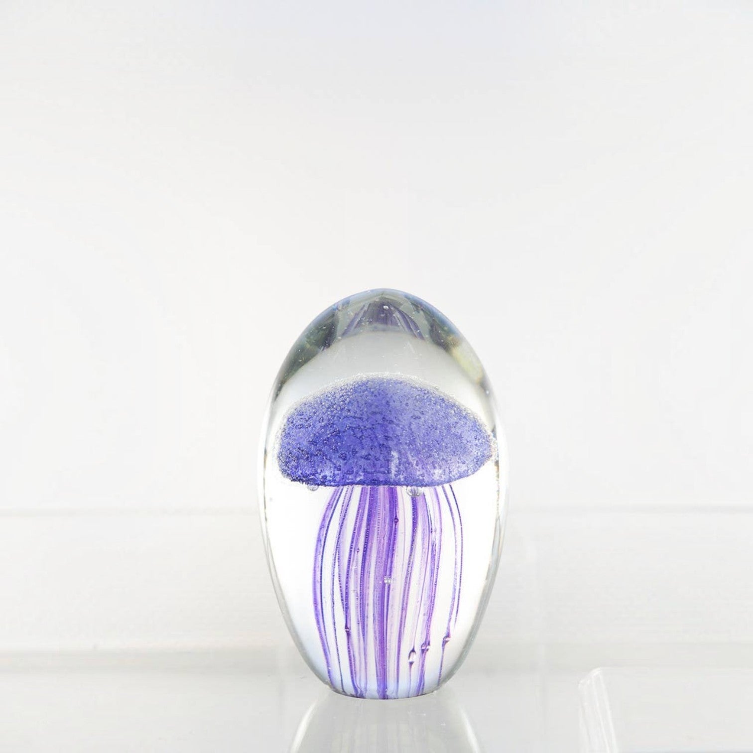Mellow Monkey purple glass jellyfish paperweight with detailed tentacles inside a clear oval glass dome