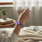 Mellow Monkey Purple Haze Feelzies sensory bracelet on a woman's wrist, featuring a squishy, glittery purple design.