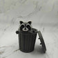 Mellow Monkey articulated raccoon fidget toy in a grey 3D printed trash can on a marble surface