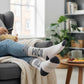 Mellow Monkey crew socks with a raccoon graphic and Here for the Snacks text, featuring grey stripes and accents.