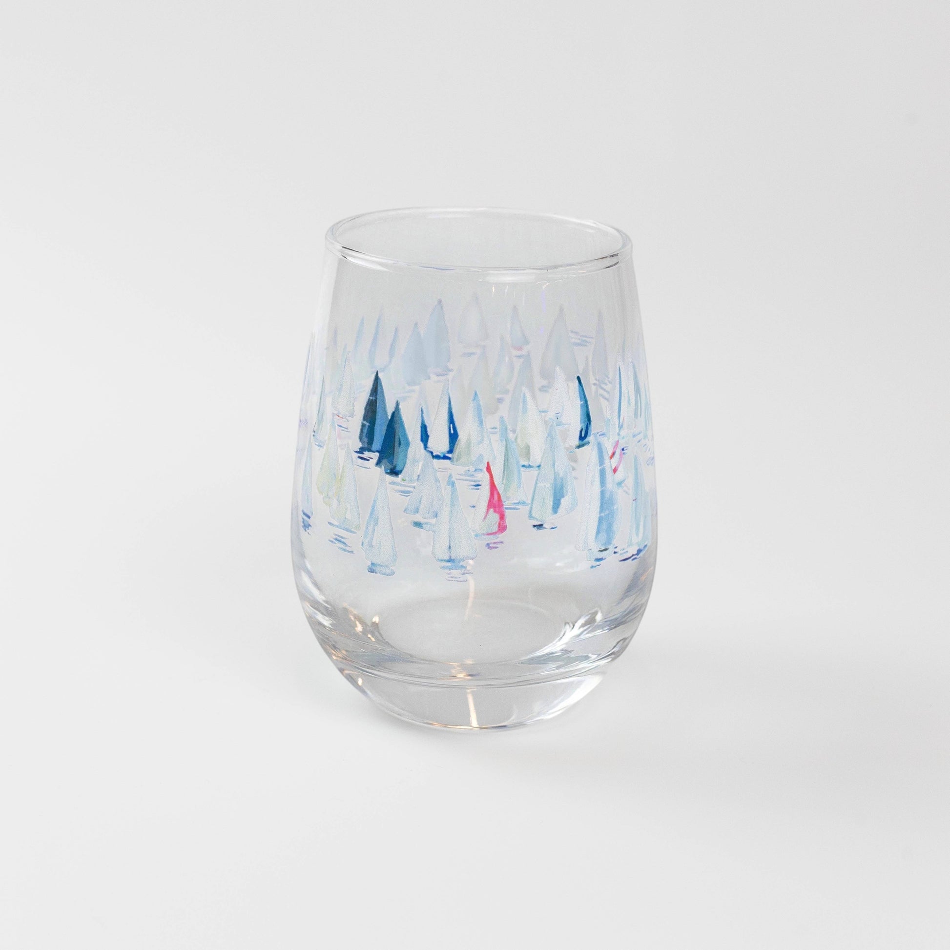 Mellow Monkey Race Day stemless wine glass with a watercolor print of sailboats in shades of blue and pink.