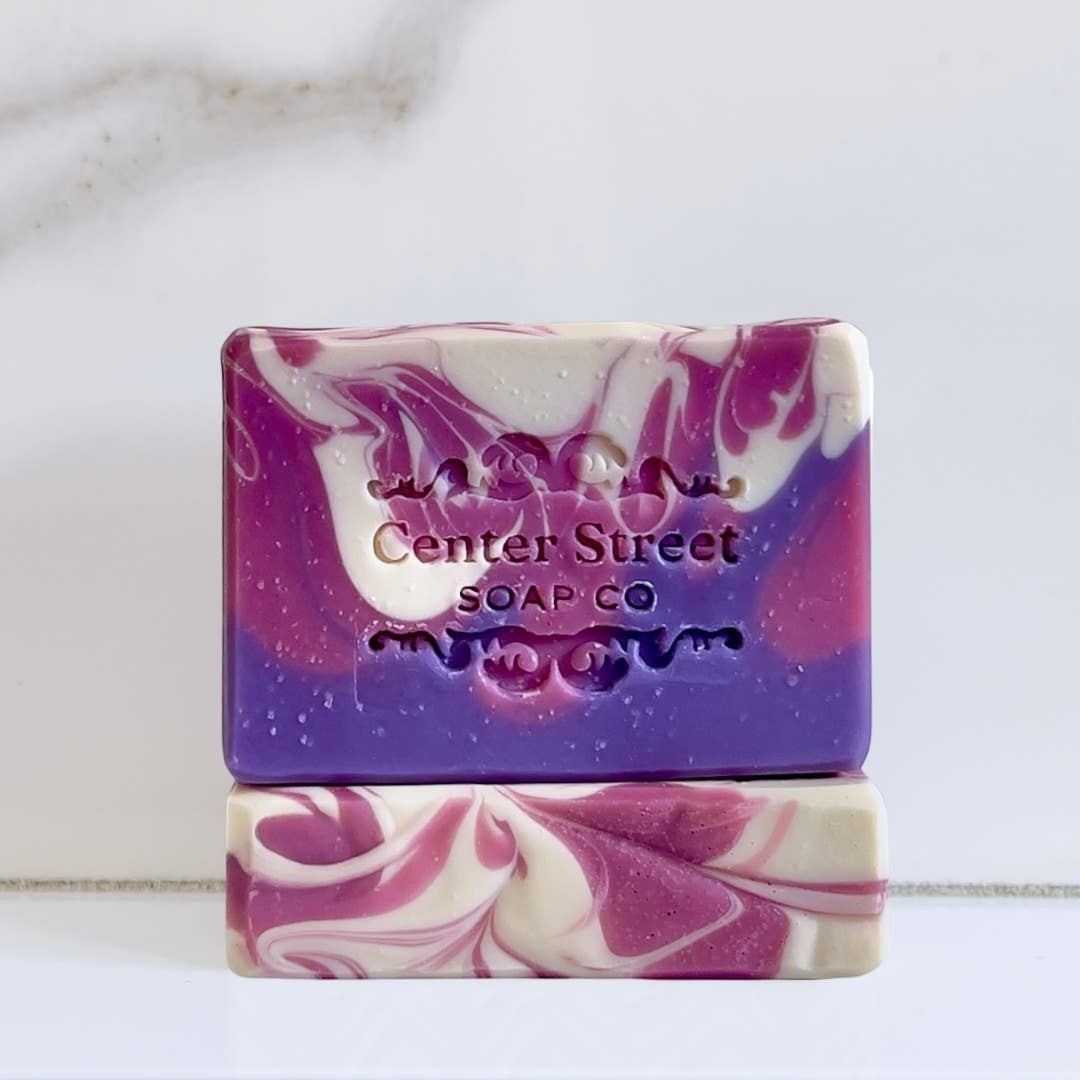 Mellow Monkey handmade artisan soap bar with purple, pink, and white swirl patterns and embossed logo detail.