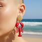 Mellow Monkey red and gold shell and lobster drop earrings, 2.75 inches long, playful ocean-inspired design.