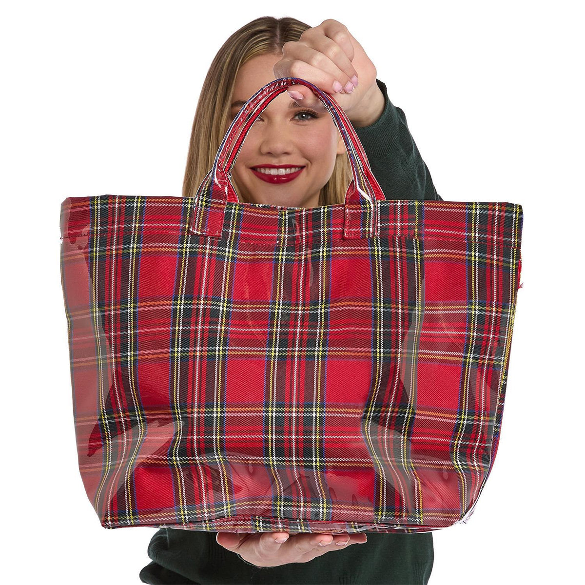A woman holding a Mellow Monkey red tartan plaid nylon tote bag with a glossy PVC finish for holiday shopping.